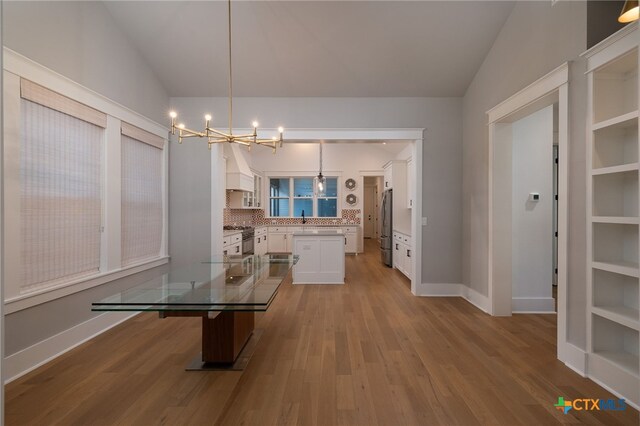 645 Center Grn, New Braunfels, TX 78130 - dining area with baseboards, lofted ceiling, wood finished floors, and a chandelier