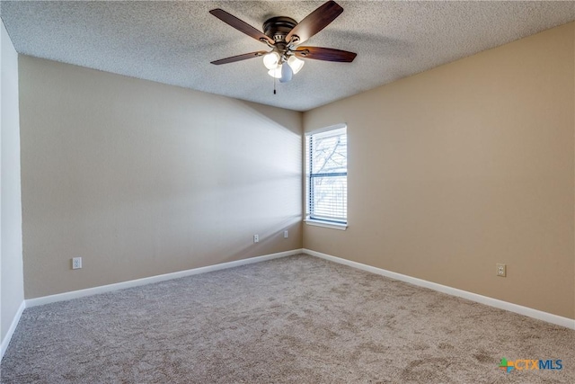 carpeted spare room featuring ceiling fan, baseboards, and a textured ceiling