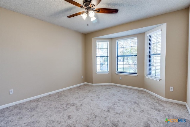 spare room with baseboards, a textured ceiling, ceiling fan, and carpet