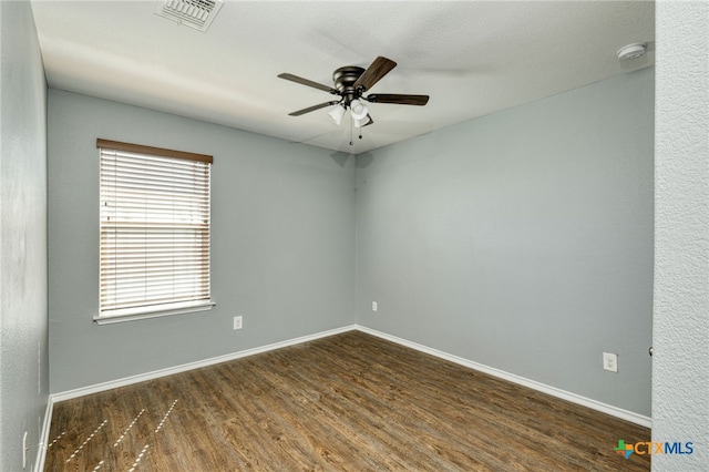 spare room featuring dark wood-type flooring and ceiling fan