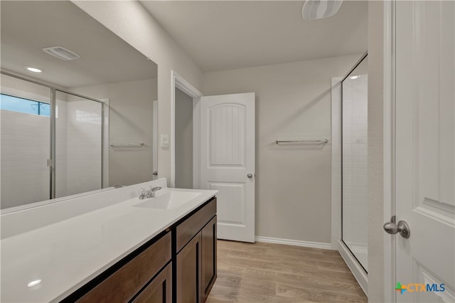 bathroom with wood-type flooring, an enclosed shower, and vanity