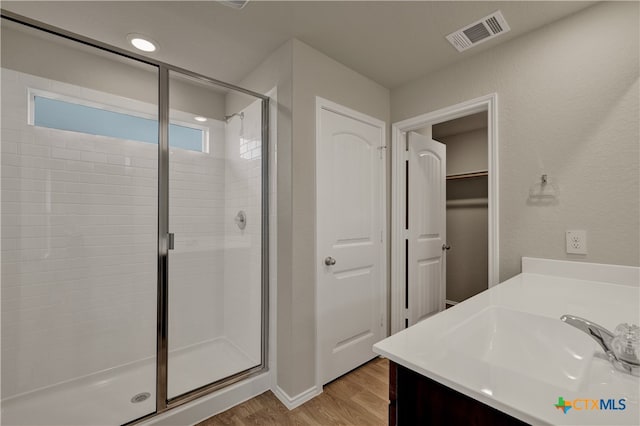 bathroom featuring vanity, a shower with door, and hardwood / wood-style floors