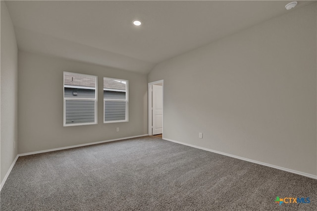 carpeted empty room with vaulted ceiling