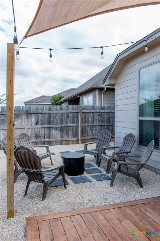 view of patio featuring an outdoor fire pit and fence