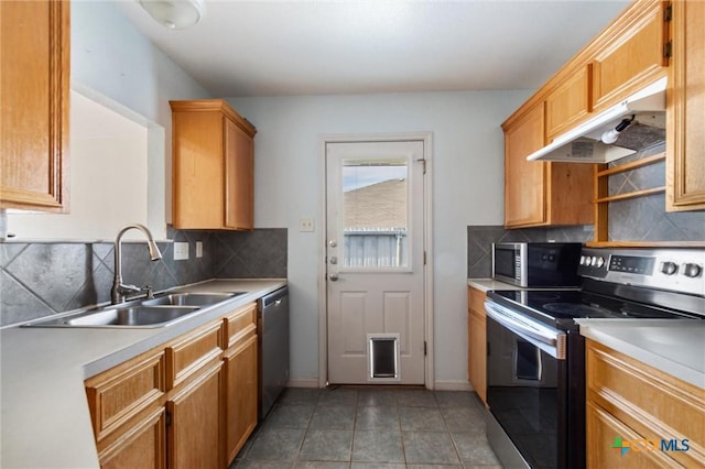 kitchen with a sink, under cabinet range hood, backsplash, appliances with stainless steel finishes, and light countertops