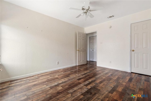 unfurnished bedroom featuring ceiling fan, visible vents, baseboards, and dark wood finished floors