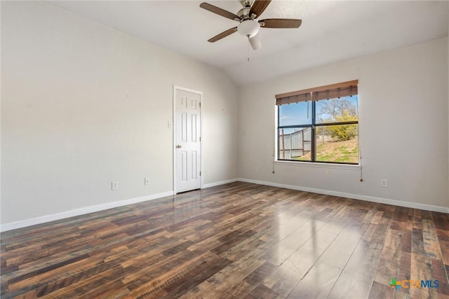 spare room with dark wood finished floors, vaulted ceiling, baseboards, and ceiling fan