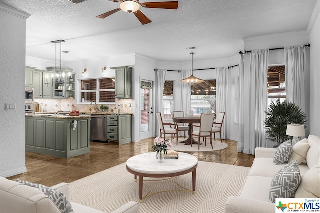 living room with ceiling fan with notable chandelier, ornamental molding, and a textured ceiling