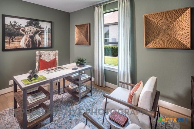 office space featuring baseboards and wood finished floors