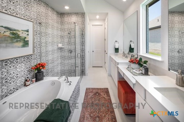 bathroom featuring a bath, a stall shower, double vanity, and recessed lighting