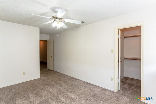 707 Bond St, Copperas Cove, TX 76522 - unfurnished bedroom with carpet flooring, a walk in closet, ceiling fan, a closet, and a textured ceiling