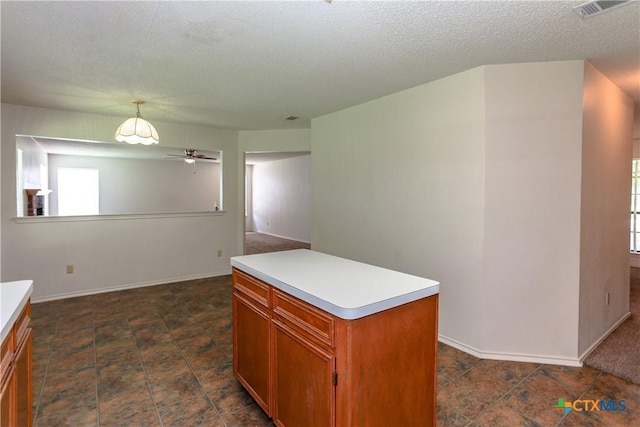 707 Bond St, Copperas Cove, TX 76522 - kitchen with light countertops, plenty of natural light, brown cabinets, a kitchen island, and a textured ceiling