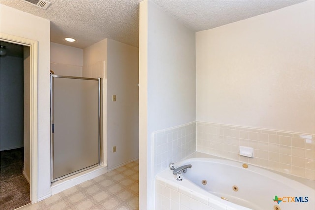 707 Bond St, Copperas Cove, TX 76522 - bathroom with a shower stall, a jetted tub, tile patterned floors, and a textured ceiling