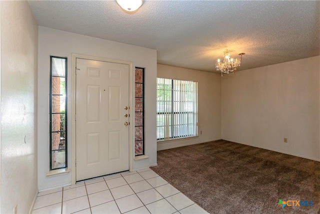 707 Bond St, Copperas Cove, TX 76522 - foyer featuring a chandelier, light carpet, a textured ceiling, and light tile patterned floors
