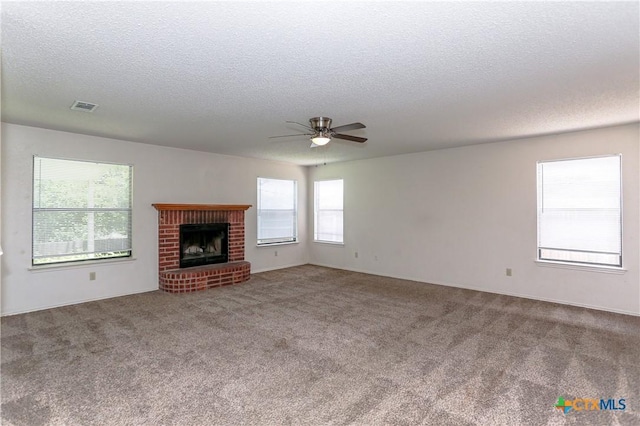 707 Bond St, Copperas Cove, TX 76522 - unfurnished living room with a textured ceiling, ceiling fan, carpet flooring, and a brick fireplace