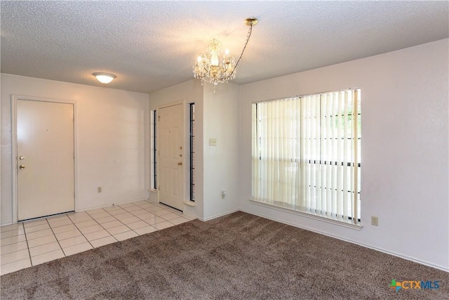 707 Bond St, Copperas Cove, TX 76522 - foyer entrance with light carpet, a chandelier, a textured ceiling, and light tile patterned flooring