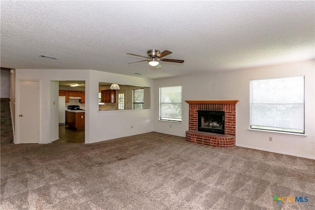707 Bond St, Copperas Cove, TX 76522 - unfurnished living room featuring a textured ceiling, a ceiling fan, a fireplace, and carpet