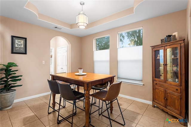 404 N Austin St, Buda, TX 78610 - dining area featuring arched walkways, a raised ceiling, and light tile patterned floors