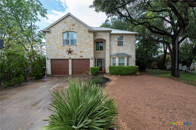 404 N Austin St, Buda, TX 78610 - french country style house featuring stone siding, driveway, a garage, and a metal roof