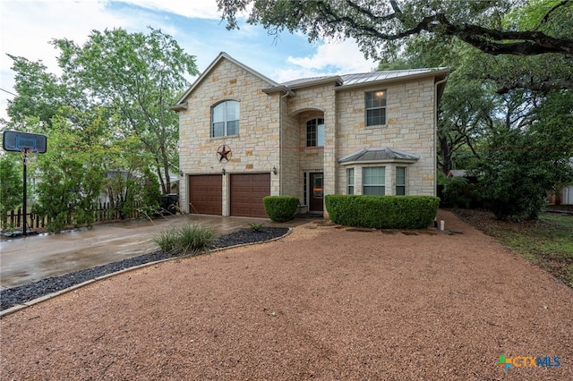 404 N Austin St, Buda, TX 78610 - french country style house featuring stone siding, a garage, driveway, a metal roof, and a standing seam roof