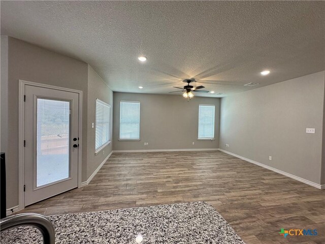interior space featuring wood finished floors, a textured ceiling, recessed lighting, and ceiling fan