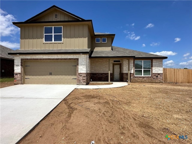 craftsman house featuring driveway, board and batten siding, fence, a garage, and brick siding