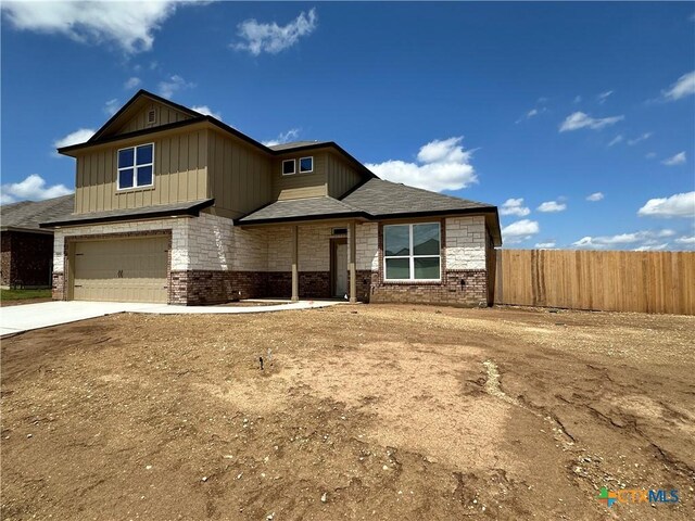 craftsman house featuring concrete driveway, an attached garage, fence, and brick siding