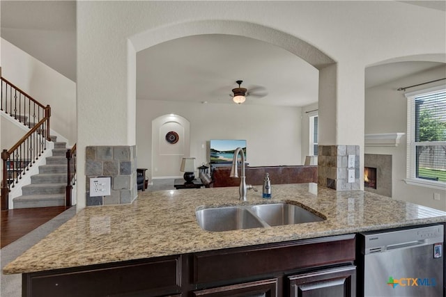 6333 Iris Run, New Braunfels, TX 78132 - kitchen featuring stainless steel dishwasher, a lit fireplace, and arched walkways