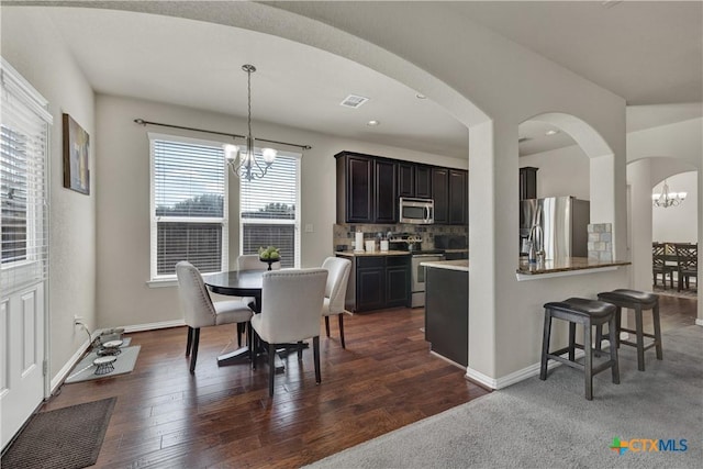 6333 Iris Run, New Braunfels, TX 78132 - dining space with a chandelier, arched walkways, and dark wood finished floors