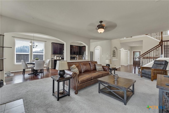 6333 Iris Run, New Braunfels, TX 78132 - living area with a ceiling fan, arched walkways, stairs, a chandelier, and wood finished floors