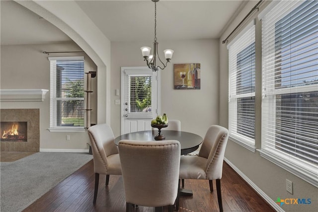 6333 Iris Run, New Braunfels, TX 78132 - dining room with a chandelier, plenty of natural light, dark wood-type flooring, and a tiled fireplace