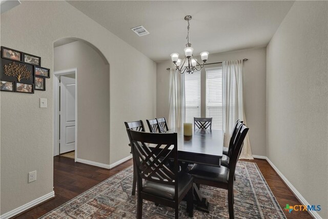 6333 Iris Run, New Braunfels, TX 78132 - dining space featuring arched walkways, a chandelier, and dark wood-style flooring