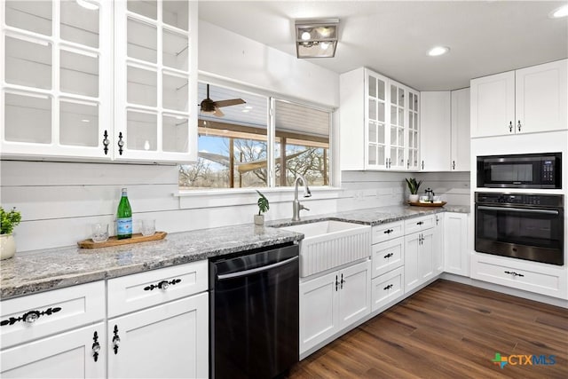 kitchen with built in microwave, dark wood-style flooring, a sink, oven, and dishwasher