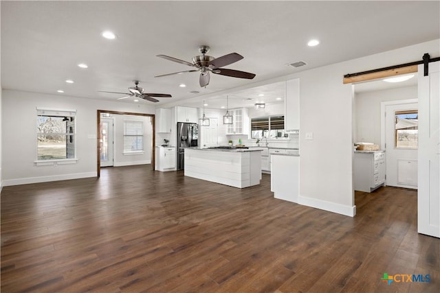 kitchen featuring visible vents, dark wood-type flooring, a barn door, recessed lighting, and white cabinets