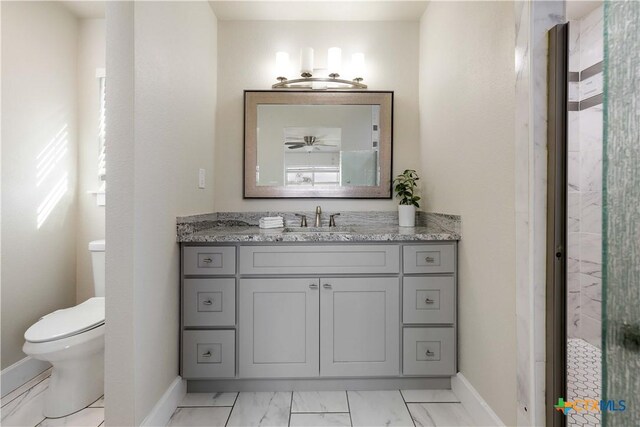 bathroom featuring vanity, toilet, baseboards, and marble finish floor