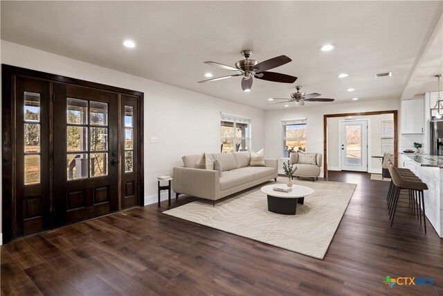 living area with dark wood finished floors, recessed lighting, visible vents, and baseboards