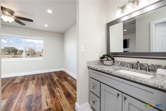 bathroom with vanity, wood finished floors, baseboards, a ceiling fan, and recessed lighting