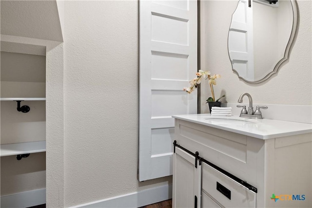 bathroom featuring vanity and a textured wall