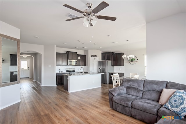 living room with dark wood-type flooring, sink, and ceiling fan