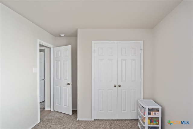 bedroom with light carpet and a closet