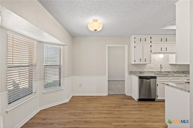 kitchen with white cabinetry, sink, light stone counters, and dishwasher