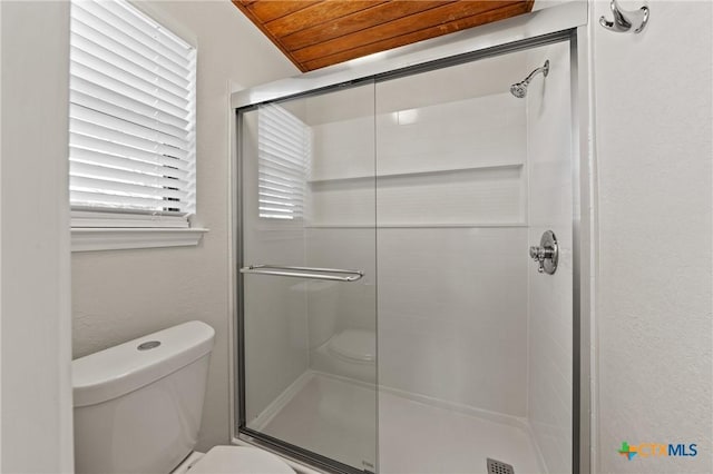 bathroom featuring wood ceiling, a shower with door, and toilet