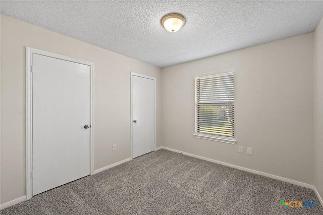 unfurnished bedroom with carpet and a textured ceiling