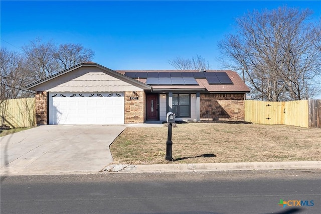 ranch-style house with a garage, a front lawn, and solar panels