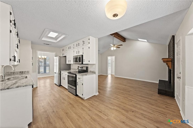 kitchen featuring stainless steel appliances, sink, ceiling fan with notable chandelier, and white cabinets