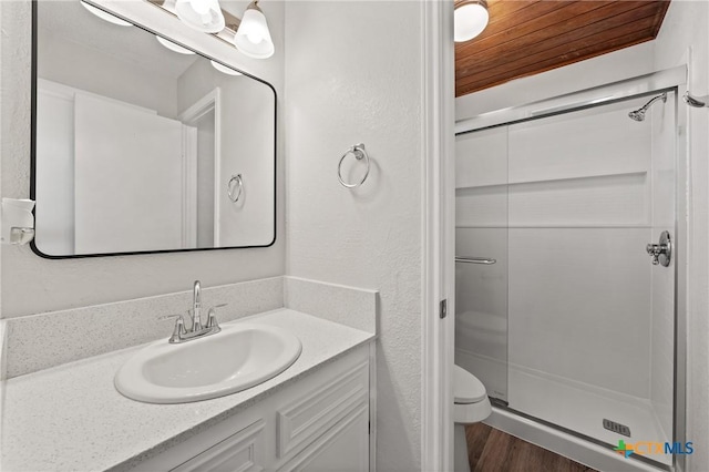 bathroom with wood ceiling, hardwood / wood-style flooring, vanity, toilet, and walk in shower