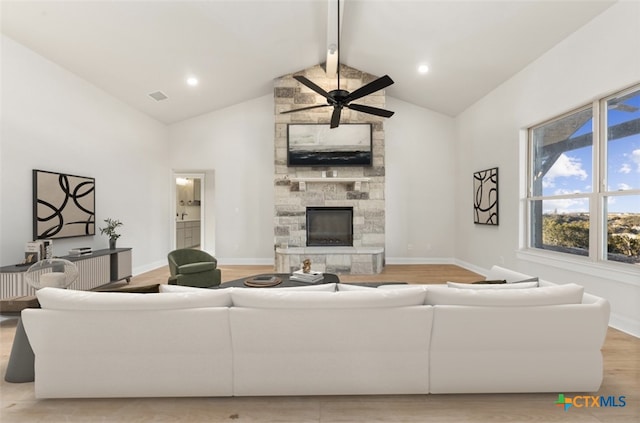 living room with beam ceiling, ceiling fan, light hardwood / wood-style flooring, high vaulted ceiling, and a fireplace