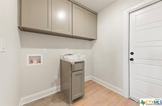 washroom with hookup for a washing machine, cabinets, and light hardwood / wood-style floors