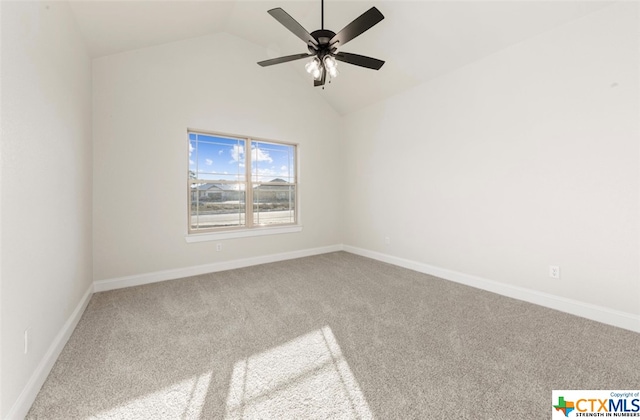 carpeted empty room featuring ceiling fan and vaulted ceiling