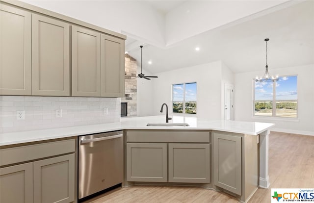 kitchen with kitchen peninsula, a wealth of natural light, sink, and stainless steel dishwasher